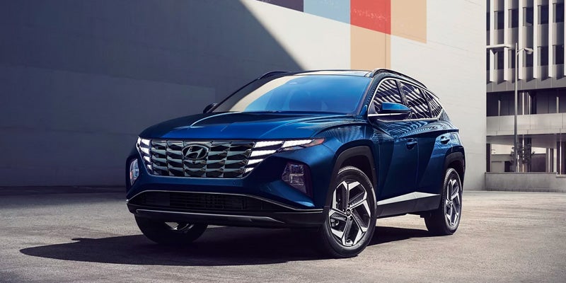 Blue Hyundai Tucson SUV parked in an urban setting.