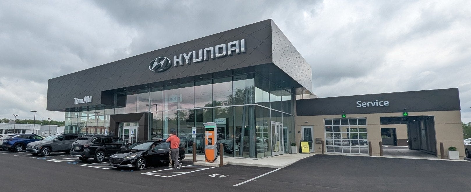 A modern Hyundai dealership building displays its logo and offers electric vehicle charging stations.