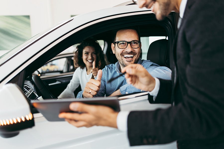 Customer reviewing final vehicle details with a dealership representative during the vehicle delivery process.